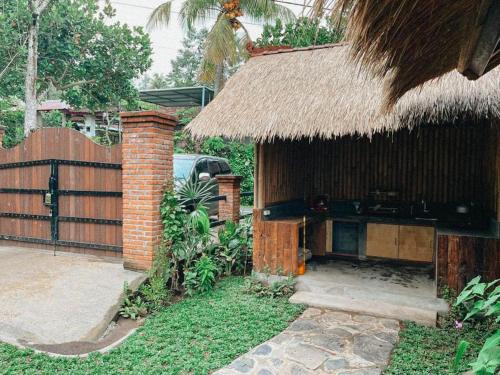 a small hut with a thatch roof and a fence at Pondok Apsari 2 in Singaraja