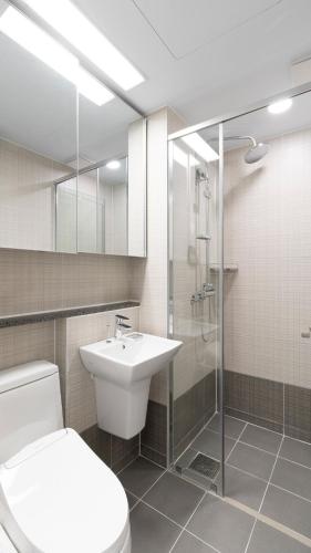 a bathroom with a toilet and a sink and a shower at Donghae Oceancity Residence Hotel in Donghae