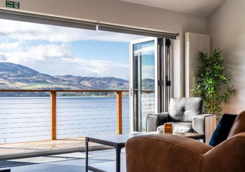 a living room with a view of the water at Shoreland Lodges - Holly Lodge in Fort Augustus