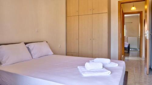 a bedroom with a white bed with towels on it at Spiridoula's Apartments Corfu in Perama