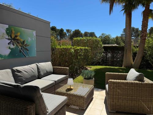 une terrasse avec un canapé, des chaises et une télévision. dans l'établissement La Terrasse de Santa Lucia, à Saint-Raphaël