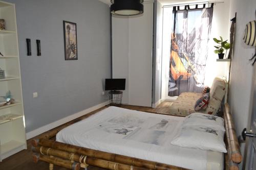 En eller flere senger på et rom på Grande chambre avec lit Bambou et canapé lit