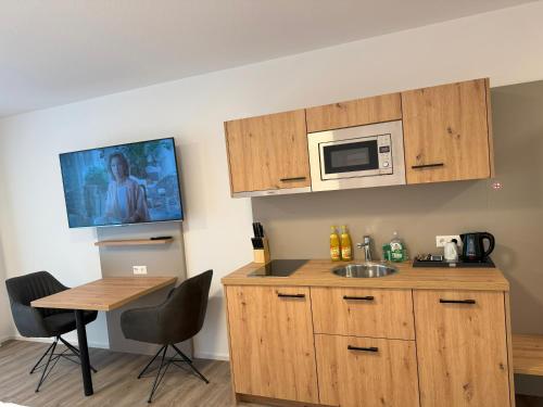 a kitchen with a sink and a microwave at MEIN MOTEL - Self Check-in in Oberndorf am Neckar