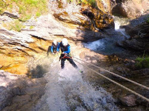 zwei Menschen auf einer Seilbrücke über einen Fluss in der Unterkunft Ferienwohnungen "Adventure Panorama" Appartement Falken Top 8 in Warth am Arlberg