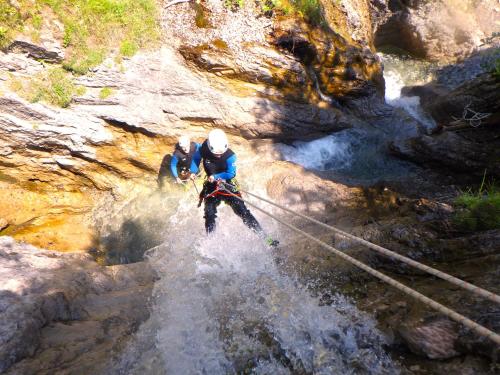 two people on a rope bridge over a river at Ferienwohnungen "Adventure Panorama" Appartement Falken Top 8 in Warth am Arlberg