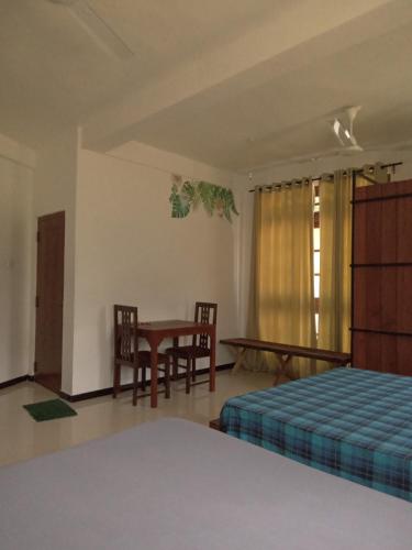 a bedroom with a bed and a table and chairs at Metro Stay in Kurunegala
