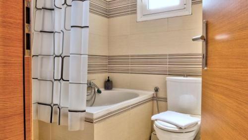 a bathroom with a toilet and a bath tub at Spiridoula's Apartments Corfu in Perama