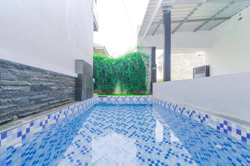 Una piscina en un edificio con azulejos azules en el suelo. en Villa Tera Private Pool and Karaoke, en Tlekung