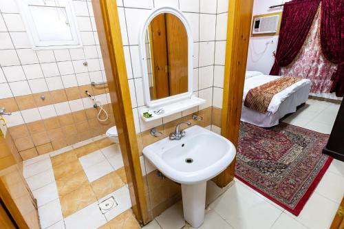 uma casa de banho com um lavatório, um chuveiro e um WC. em شقق العييري المخدومة الباحة 02 em Al Baha
