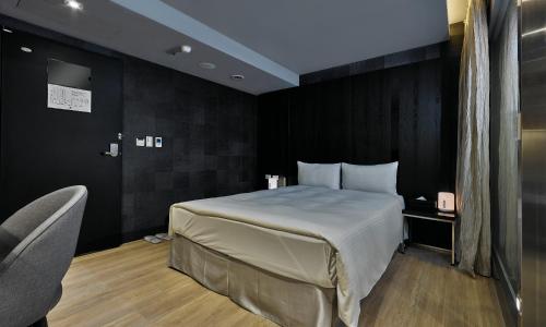 a hotel room with a bed and a chair at 安庭台北商旅 in Taipei
