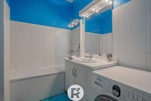 une salle de bain avec un lavabo et une machine à laver dans l'établissement R'Apparts T3 Espace Détente, à Grenoble