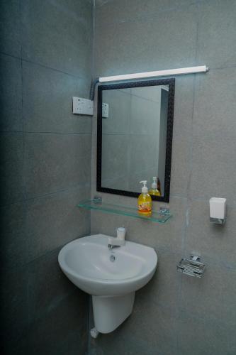 a bathroom with a white sink and a mirror at The Chapters in Jaffna