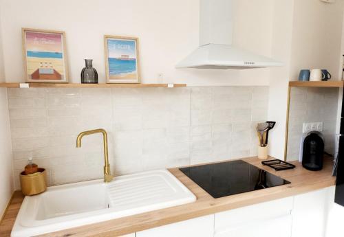 une cuisine avec un évier et un plan de travail dans l'établissement Superbe duplex 50 mètres de la plage, à Le Portel
