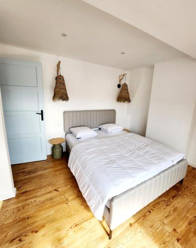 une chambre avec un lit blanc et un parquet dans l'établissement Superbe duplex 50 mètres de la plage, à Le Portel
