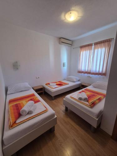 a room with three beds and a window at Pansion Speranza Međugorje in Međugorje