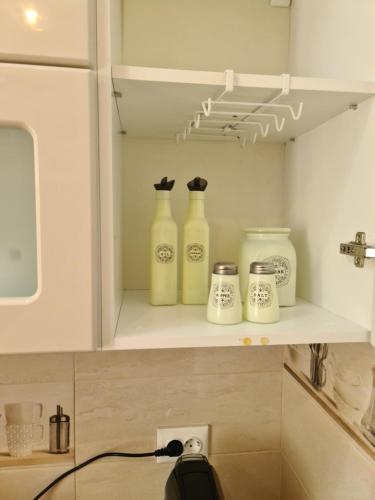 Hay cuatro botellas en un estante en una cocina. en MB Studio, en Brasov