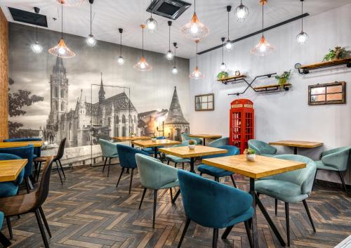 a restaurant with tables and chairs and a mural of a church at Hotel Memories OldTown in Budapest