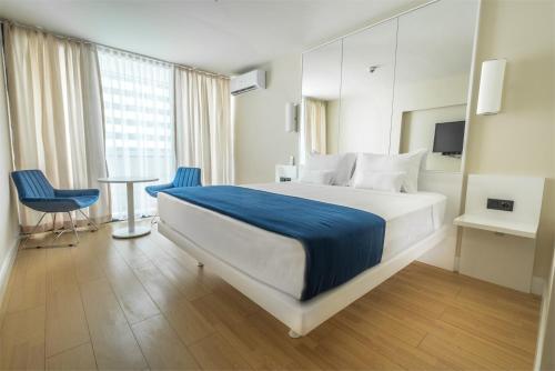 een hotelkamer met een bed en een tafel en stoelen bij ORBI CITY batumi in Batoemi