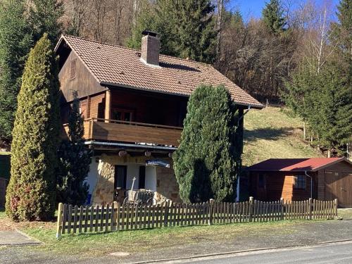 uma casa com uma cerca de madeira em frente em Detached holiday residence in the wonderfully beautiful Harz em Kamschlacken