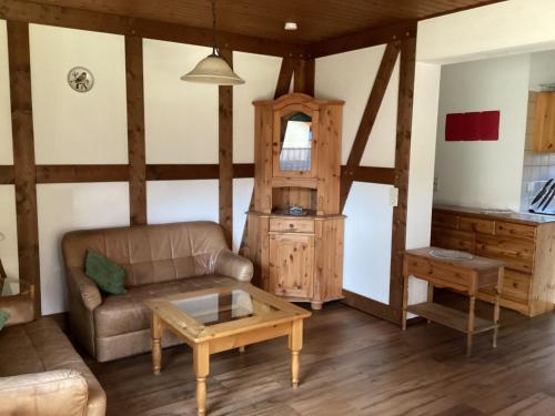 uma sala de estar com um sofá e uma mesa em Detached holiday residence in the wonderfully beautiful Harz em Kamschlacken