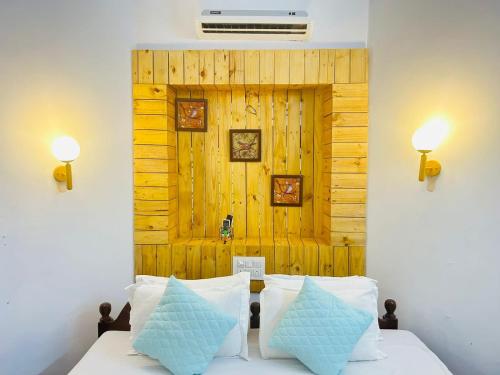 a bedroom with a bed with two blue pillows at Harbor Court, Vagator in Vagator