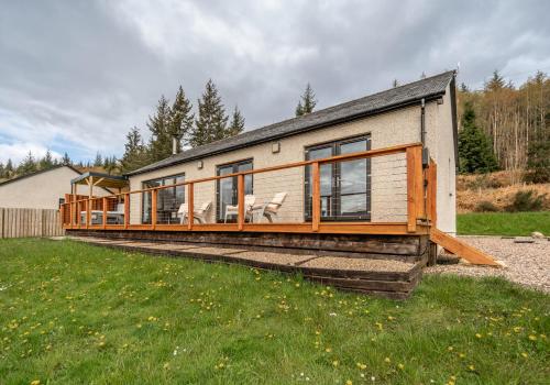 a house with a large deck on the side of it at Shoreland Lodges - Holly Lodge in Fort Augustus