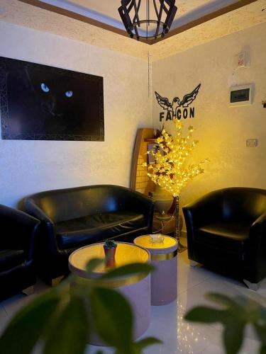 ein Wohnzimmer mit zwei Ledersesseln und einer Katze an der Wand in der Unterkunft Falcon homes in Amman