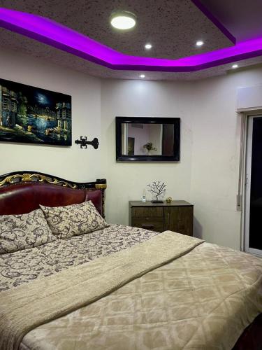 ein Schlafzimmer mit einem großen Bett mit violetter Beleuchtung in der Unterkunft Falcon homes in Amman