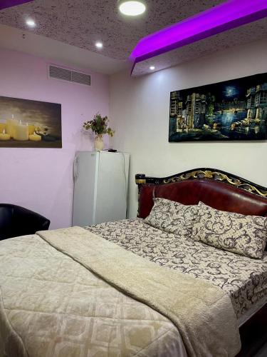 Schlafzimmer mit einem Bett und einem Kühlschrank in der Unterkunft Falcon homes in Amman