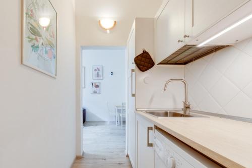 - une cuisine avec des placards blancs et un évier dans l'établissement Romantic apartment by the park - uaka7, à Prague