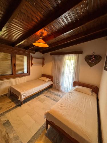 a bedroom with two beds and a wooden ceiling at Villa Ocean in Paralia Dionysiou
