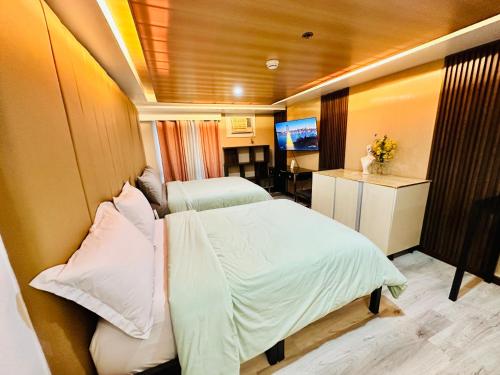 una camera con due letti e una televisione in esso di Feels Like Home Condos Abreeza Place Tower 1 & 2 a Davao