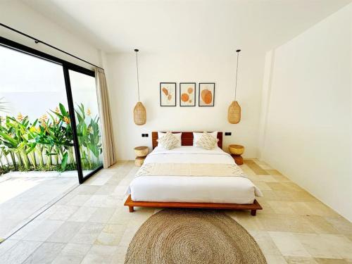 een slaapkamer met een groot bed en een groot raam bij Charming NEW 3BR Villa with Private Pool in Canggu in Tumbak Bayuh