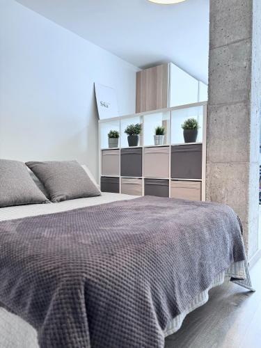 1 dormitorio con 1 cama grande y algunas plantas en SumaLoft Prensa, en Málaga