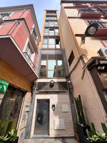 un edificio alto con una puerta delante en Ilustre Rooms by Beehive Vacances, en Málaga