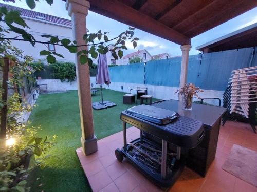 a grill sitting on a patio with a yard at O Alecrin de Bouzas Ribeira Sacra in Pereiro de Aguiar