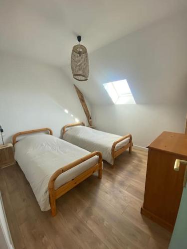 - 2 lits dans une chambre avec une lucarne dans l'établissement Chez Salomé & Théo !, à Saint-Jean-dʼArvey