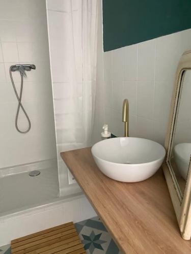 La salle de bains est pourvue d'un grand lavabo blanc sur un comptoir en bois. dans l'établissement Chez Salomé & Théo !, à Saint-Jean-dʼArvey
