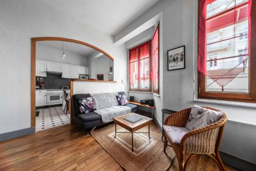 ein Wohnzimmer mit einem Sofa und einem Tisch in der Unterkunft Le Lasteyras - Appartement charmant en centre ville in Vichy