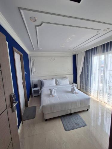 a bedroom with a large white bed with blue walls at V.I.P BOUTIQUE HOTEL in Vientiane