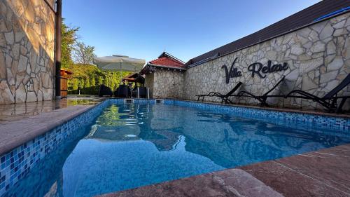 a swimming pool in front of a wall with graffiti on it at Villa Relax Tuzla in Tuzla