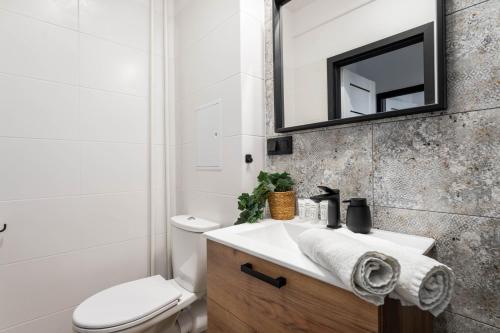 a bathroom with a sink and a toilet and a mirror at Rose Corner Rozana Mokotow in Warsaw