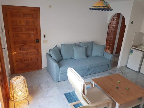 uma sala de estar com um sofá azul e uma mesa em Appartement VERA PLAYA, Vera Coast, ANDALOUSIE em Vera