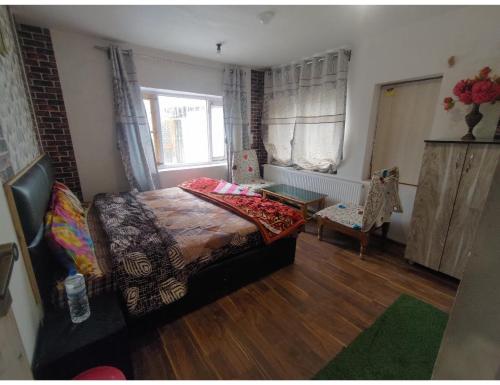 Hotel The Gulmarg Gateway Resort, Jammu and Kashmir في Tangmarg: غرفة نوم بسرير وطاولة ونافذة