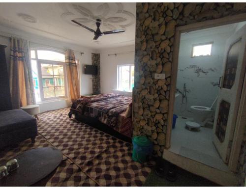 Hotel The Gulmarg Gateway Resort, Jammu and Kashmir في Tangmarg: غرفة نوم بسرير وحمام
