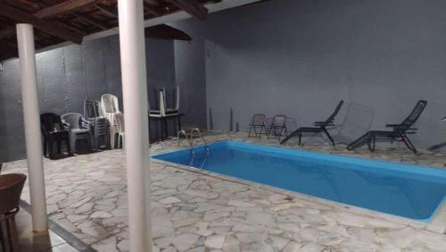 uma grande piscina com cadeiras e uma mesa em Puro Encanto Refúgio - Agrishow em Ribeirão Preto