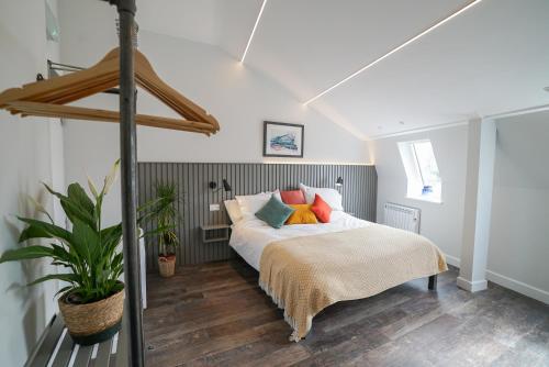 a bedroom with a bed with colorful pillows at Sgwâr in Menai Bridge
