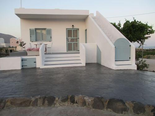 a white house with a staircase in front of it at House in vineyard in Emboríon