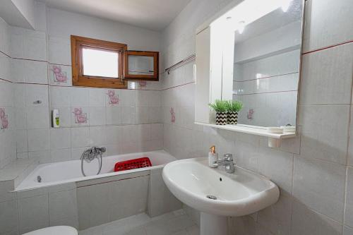 uma casa de banho branca com um lavatório e uma banheira em Arches em Agria