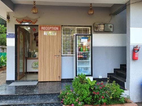 a restaurant entrance with a door and flowers in front at SURYAPRABHA HOLIDAY HOMES in Diveagar